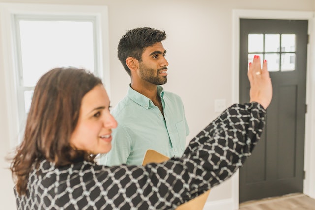 two people touring inside of empty house